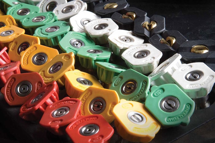 Assortment of color-coded quick-change pressure washer nozzles — red, yellow, green and white spray tips for commercial hot and cold water pressure washers at Enzo's Cleaning Systems in Ohio