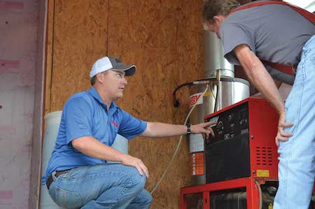 Enzo's Cleaning Systems technician performing scheduled preventative maintenance and 25-point inspection on a Hotsy hot water pressure washer in Ohio